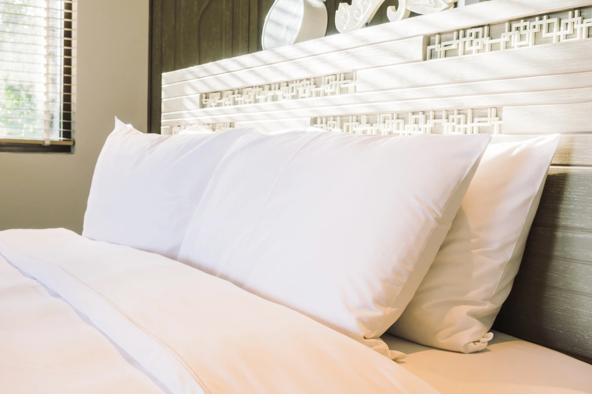 Freshly made bed with pillows arranged neatly